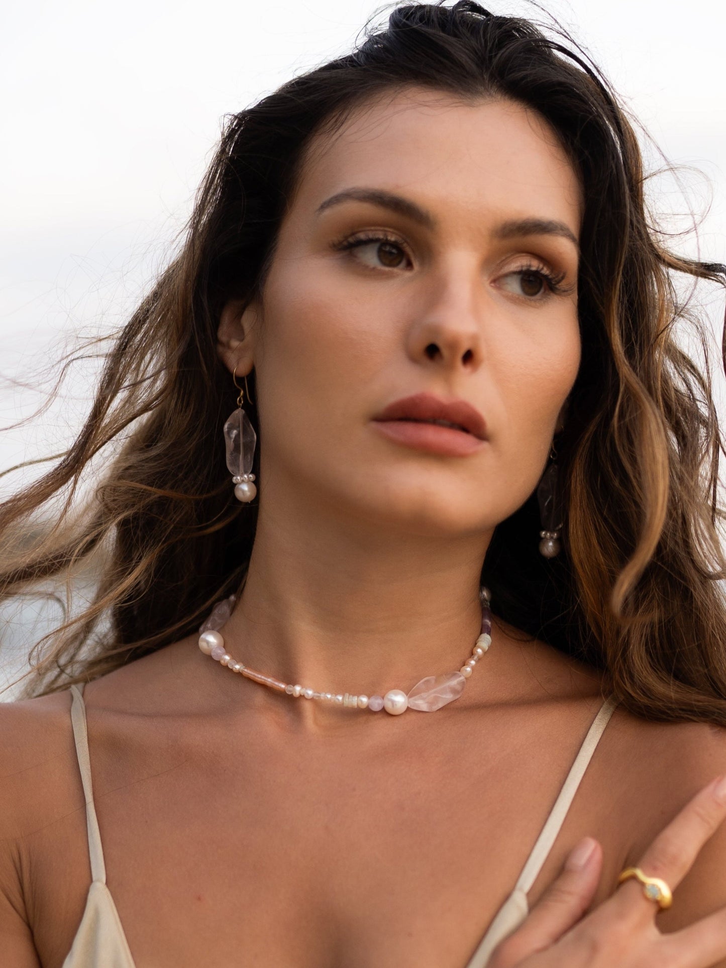 Woman wearing a beige bikini and pearl necklace on a beach