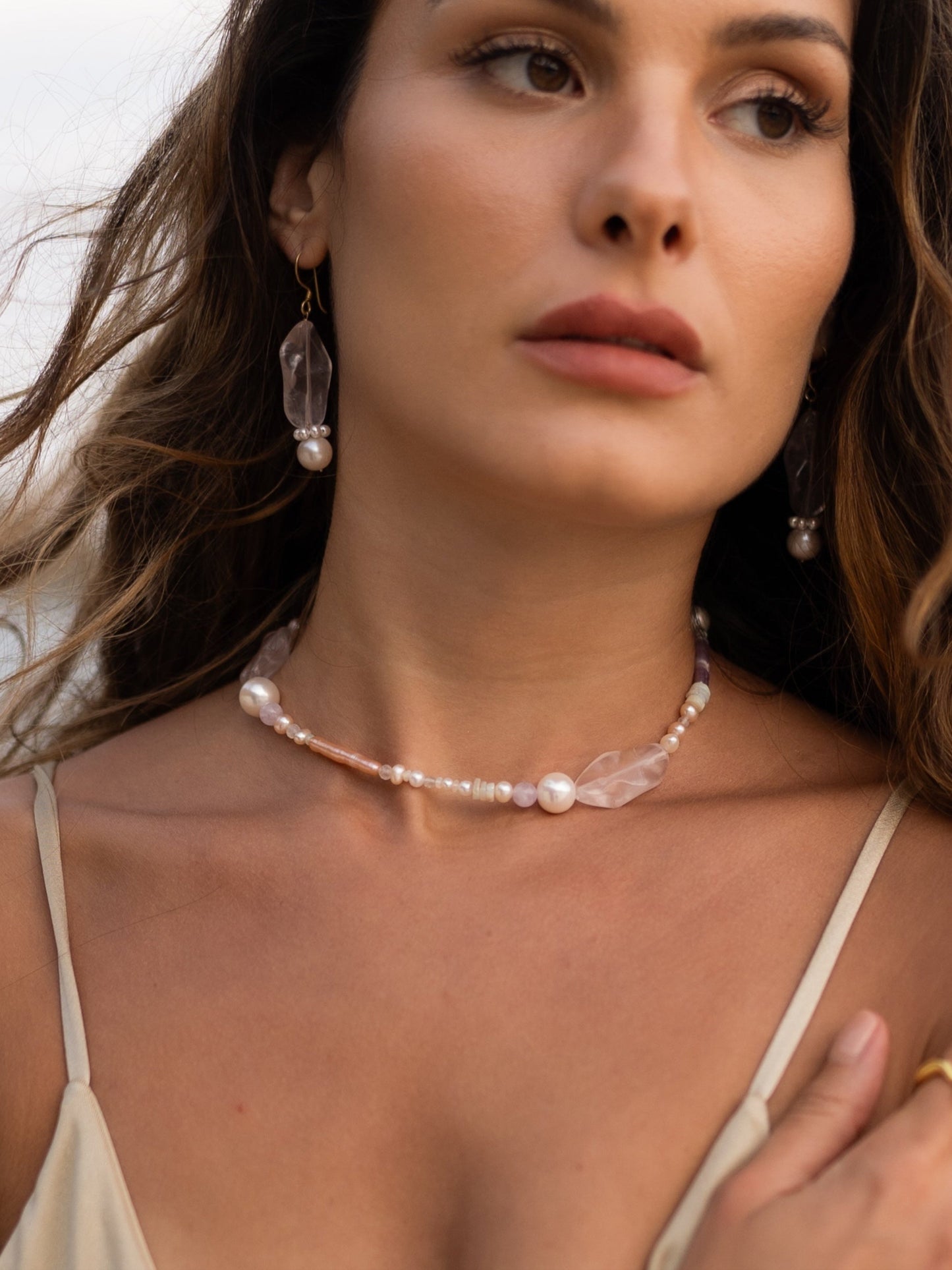 Woman wearing a pearl necklace with a neutral background
