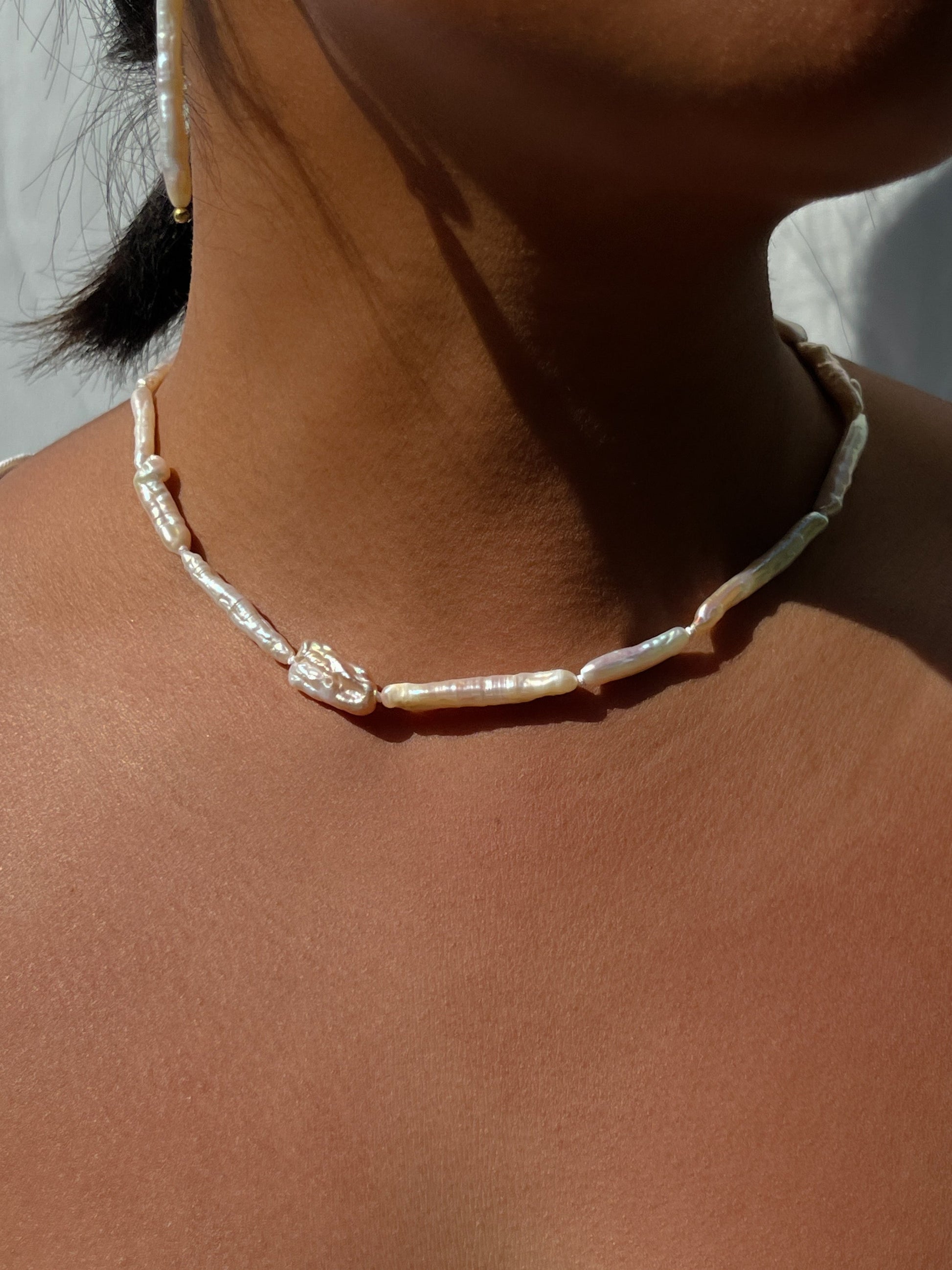 Luxe Keshi & Biwa Pearl Necklace. Biwa and Keshi pearls, naturally white with an iridescent shine and in free formed shapes feature on this stunning necklace. Elongated shaped Biwa pearls are peppered with nugget shaped Keshi pearls. This necklace is handcrafted using 100% Silk thread, and is highlighted with 14kt Gold Filled beads and hardware