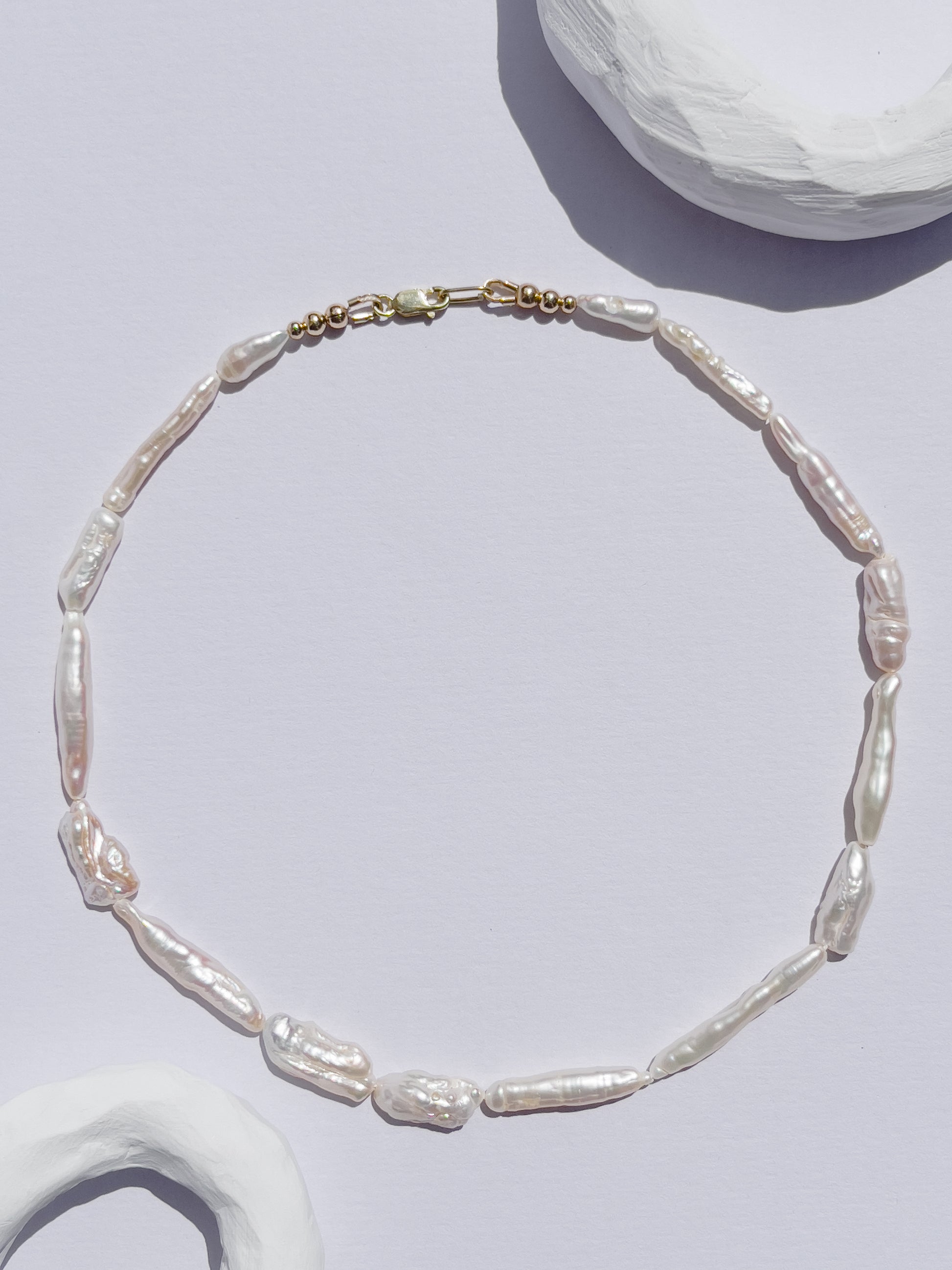 Luxe Keshi & Biwa Pearl Necklace. Biwa and Keshi pearls, naturally white with an iridescent shine and in free formed shapes feature on this stunning necklace. Elongated shaped Biwa pearls are peppered with nugget shaped Keshi pearls. This necklace is handcrafted using 100% Silk thread, and is highlighted with 14kt Gold Filled beads and hardware