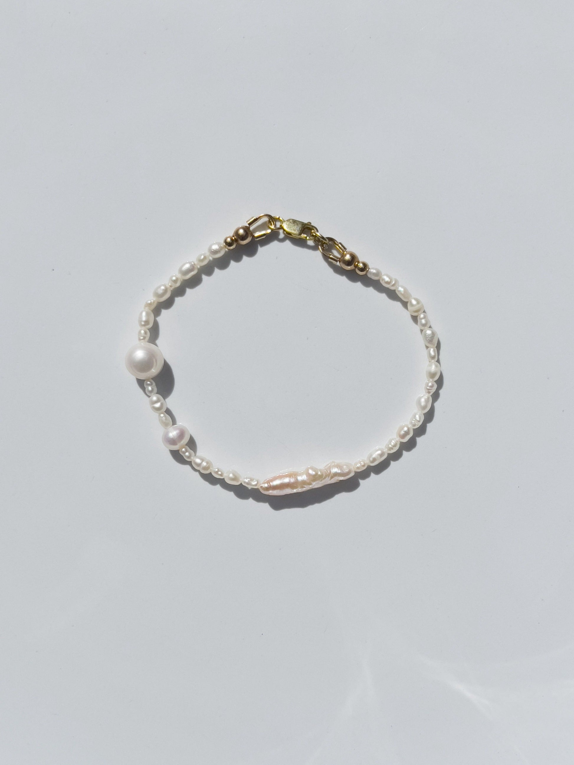 Biwa Pearl Bracelet. Natural elongated Biwa pearls placed off centre with a bold spherical Freshwater pearls. Using natural AAA quality freshwater pearls, in a minimal asymmetrical design. 14 Karat Gold filled Sterling Silver hardware finishes the piece. Designed and made by nāmaka