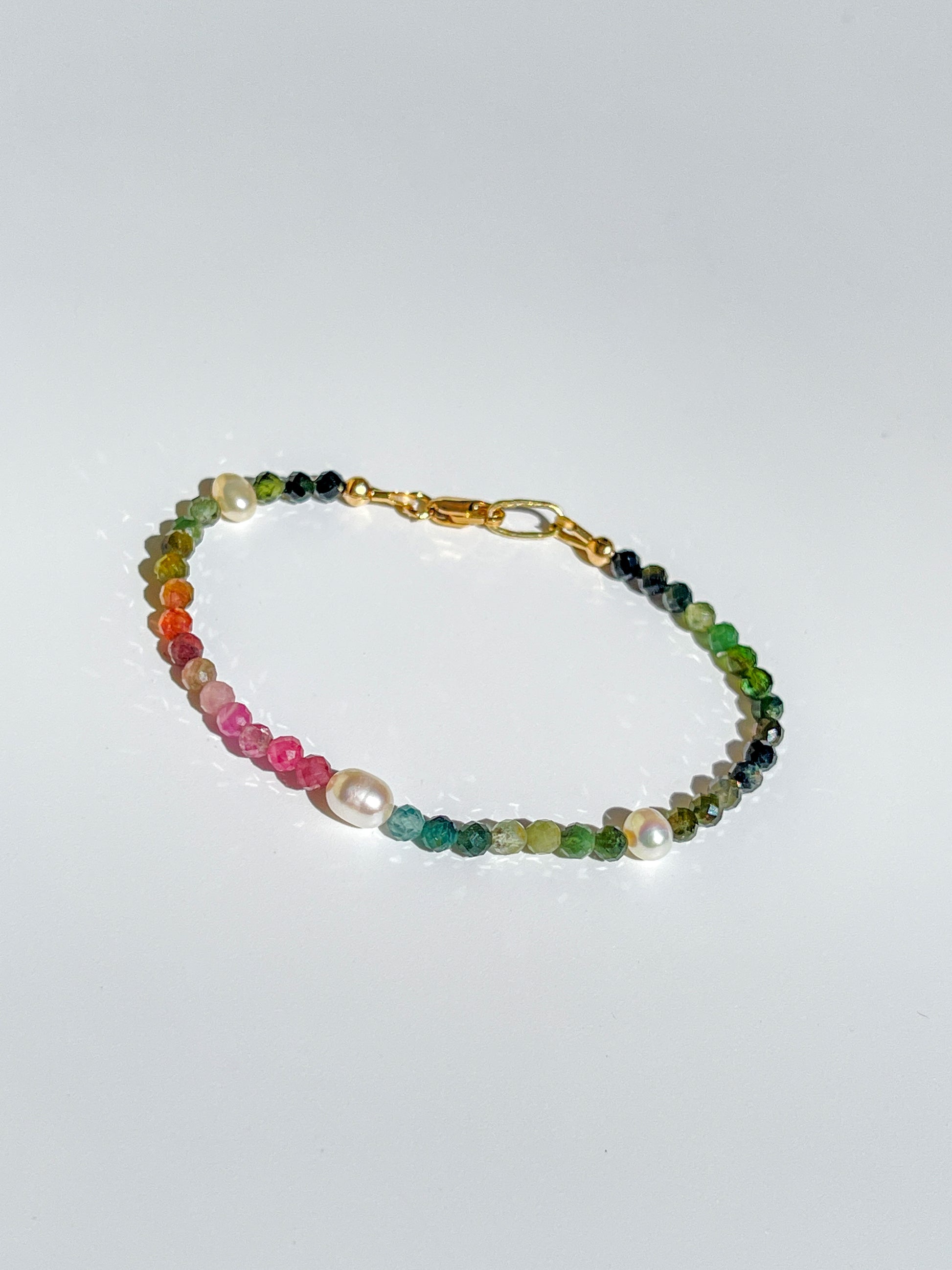 Nāmaka Tourmaline & Pearl Bracelet - Each tourmaline gem, with unique colours and patterns, sparkle and catch the eye. Teamed with a scattering of freshwater pearls highlight the piece.  This bracelet is both casual yet elegant, and can be teamed with matching earrings and necklace.  Designed & handcrafted by Nāmaka in Melbourne Australia