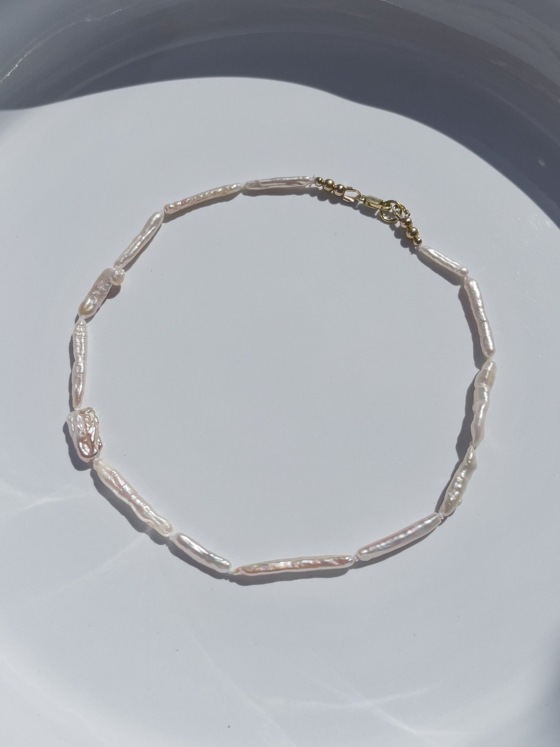 Luxe Keshi & Biwa Pearl Necklace. Biwa and Keshi pearls, naturally white with an iridescent shine and in free formed shapes feature on this stunning necklace. Elongated shaped Biwa pearls are peppered with nugget shaped Keshi pearls. This necklace is handcrafted using 100% Silk thread, and is highlighted with 14kt Gold Filled beads and hardware