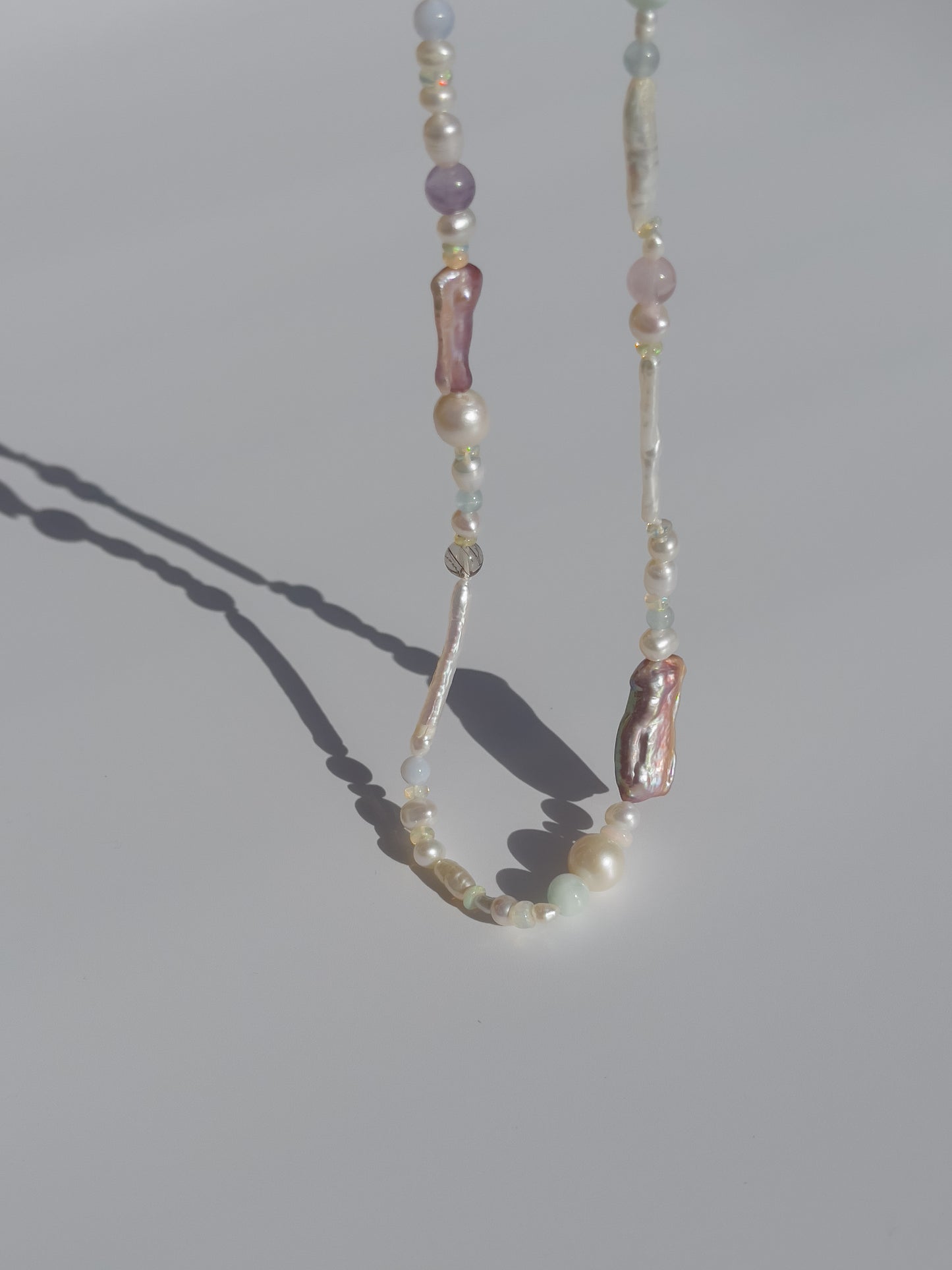 Candy Pearl & Multi-stone Necklace - Glistening in candy colours, and finished with 14 karat Gold hardware, this necklace is absolutely gorgeous. Hand crafted with a variety of Violet Keshi Pearls, South Sea Pearls, Biwa Pearls, Freshwater Pearls & Pink Freshwater Pearls. Combined with a glittery cluster of Australian Opals, Aquamarine, Blue Lace Agate, Jade, and the ultimate - The Super Seven Stone. Designed and made by nāmaka