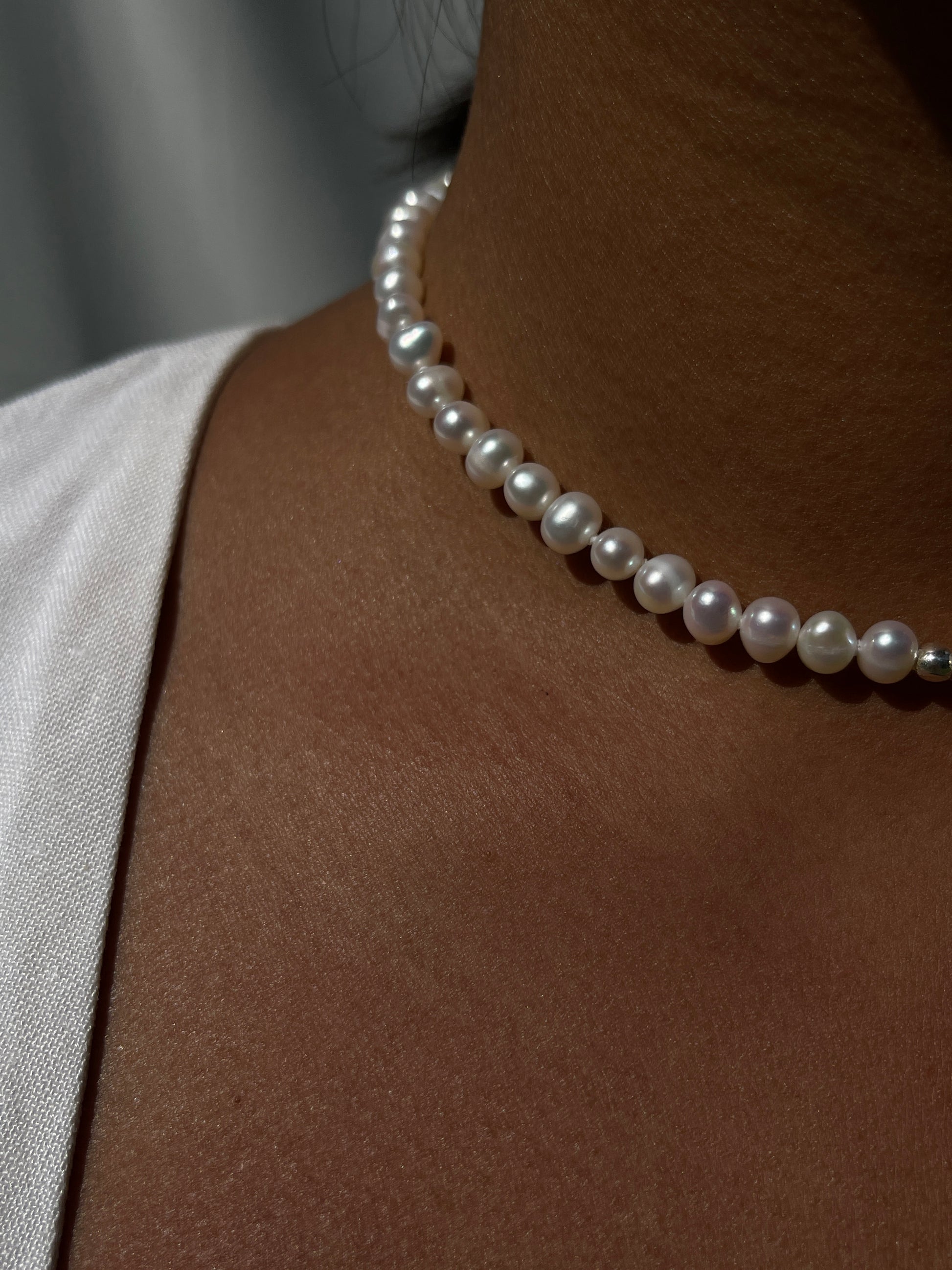 Pearl & Raw Opal Choker Necklace. Natural AA luxe pearls in a natural white are highlighted by the bright iridescent sparkle of Raw Australian Opal placed centrally on the clavicle, held in a sterling silver setting.  Personally and strung and knotted with 100% silk thread & handcrafted in Sterling Silver.   This necklace is a true statement piece.  Please note that this style is made to order, and due to the natural and raw elements, each piece is completely unique.