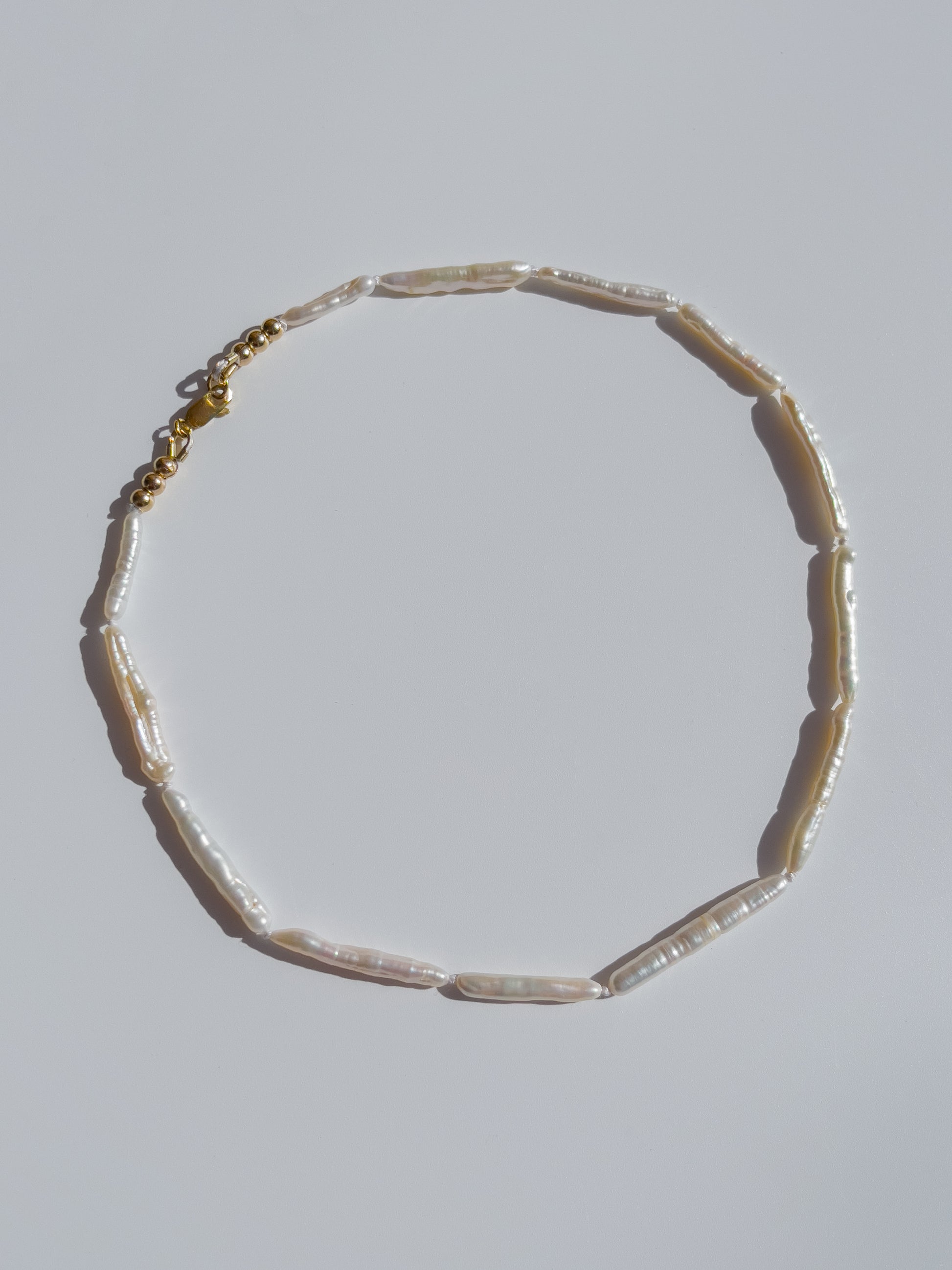 Luxe Keshi & Biwa Pearl Necklace. Biwa and Keshi pearls, naturally white with an iridescent shine and in free formed shapes feature on this stunning necklace. Elongated shaped Biwa pearls are peppered with nugget shaped Keshi pearls. This necklace is handcrafted using 100% Silk thread, and is highlighted with 14kt Gold Filled beads and hardware