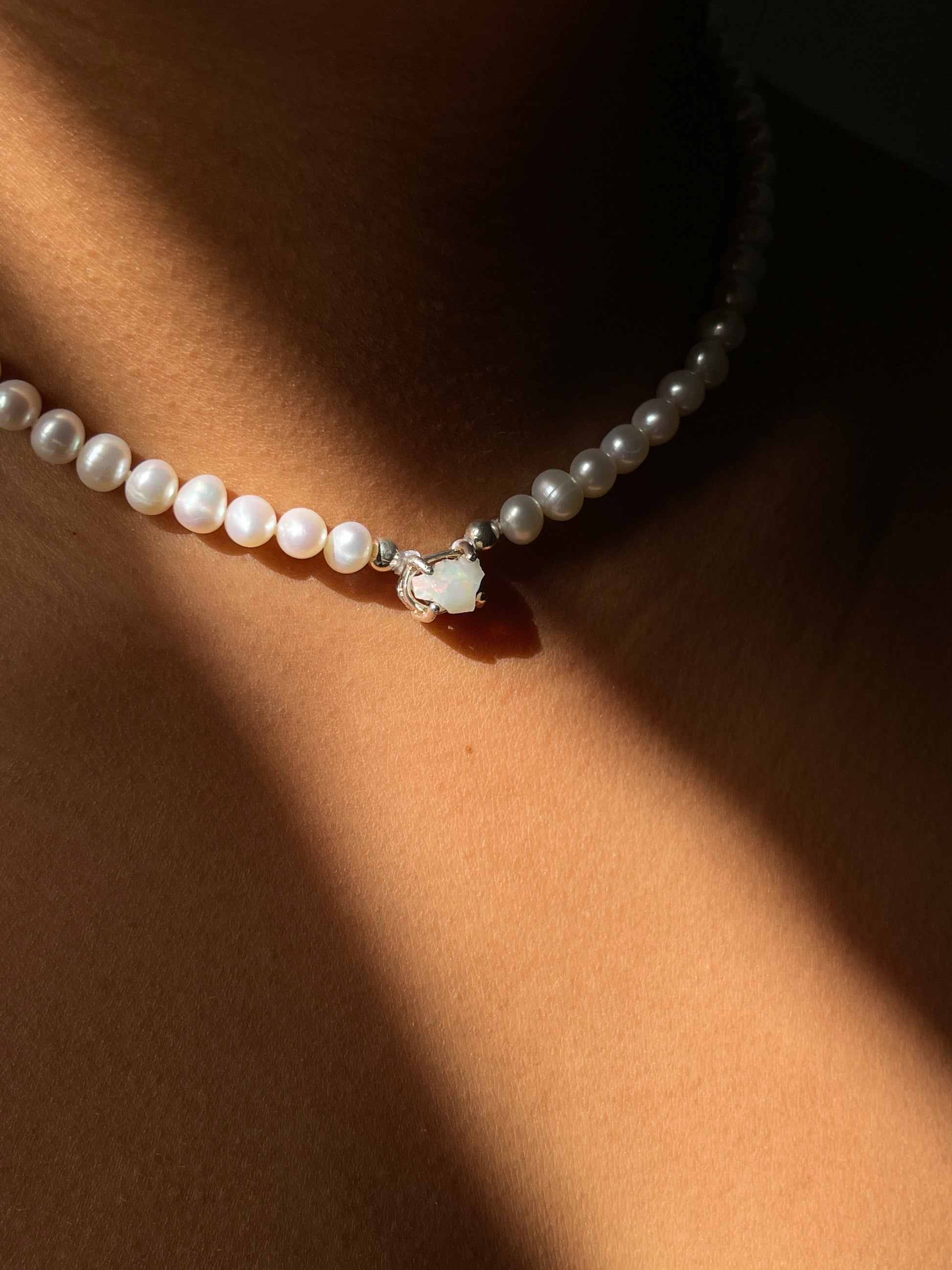 Pearl & Raw Opal Choker Necklace. Natural AA luxe pearls in a natural white are highlighted by the bright iridescent sparkle of Raw Australian Opal placed centrally on the clavicle, held in a sterling silver setting.  Personally and strung and knotted with 100% silk thread & handcrafted in Sterling Silver.   This necklace is a true statement piece.  Please note that this style is made to order, and due to the natural and raw elements, each piece is completely unique.