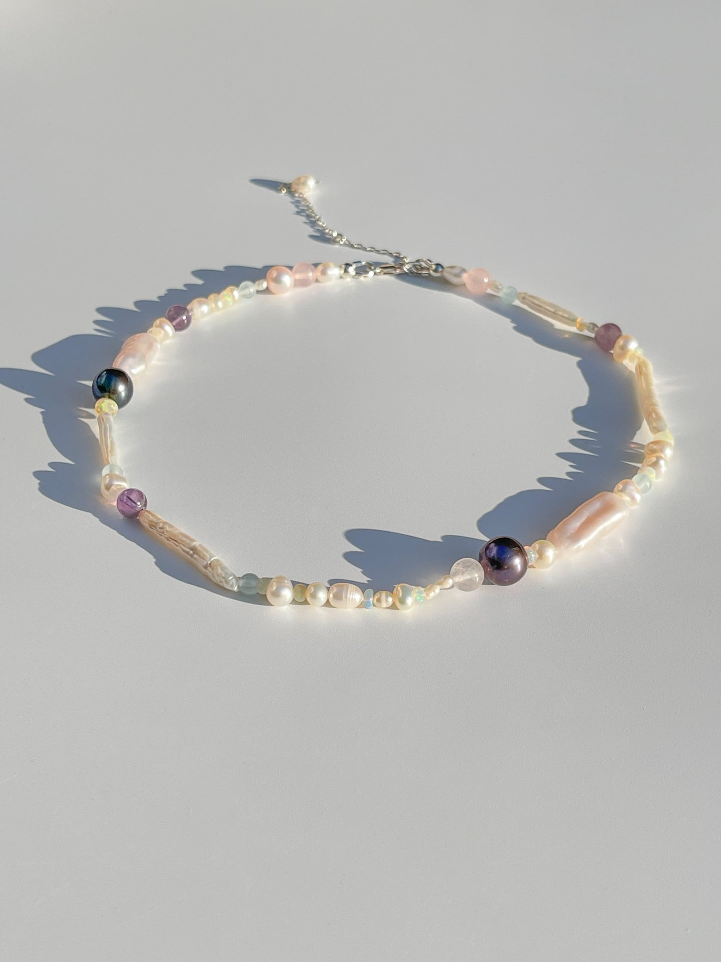 Tahitian Black Pearl & Opal Multi-Stone Choker Necklace - Glistening in candy colours, and finished with Sterling Silver hardware, this necklace is absolutely gorgeous. Hand crafted with a variety of Vibrant White Keshi Pearls, Estate re-purposed Tahitian Black Pearls, Biwa Pearls, Freshwater Pearls & Pink Freshwater Pearls. Combined with a glittery cluster of Australian Opals, Aquamarine, Blue Lace Agate, Jade, and the ultimate - The Super Seven Stone.  Designed and personally handcrafted by Nāmaka