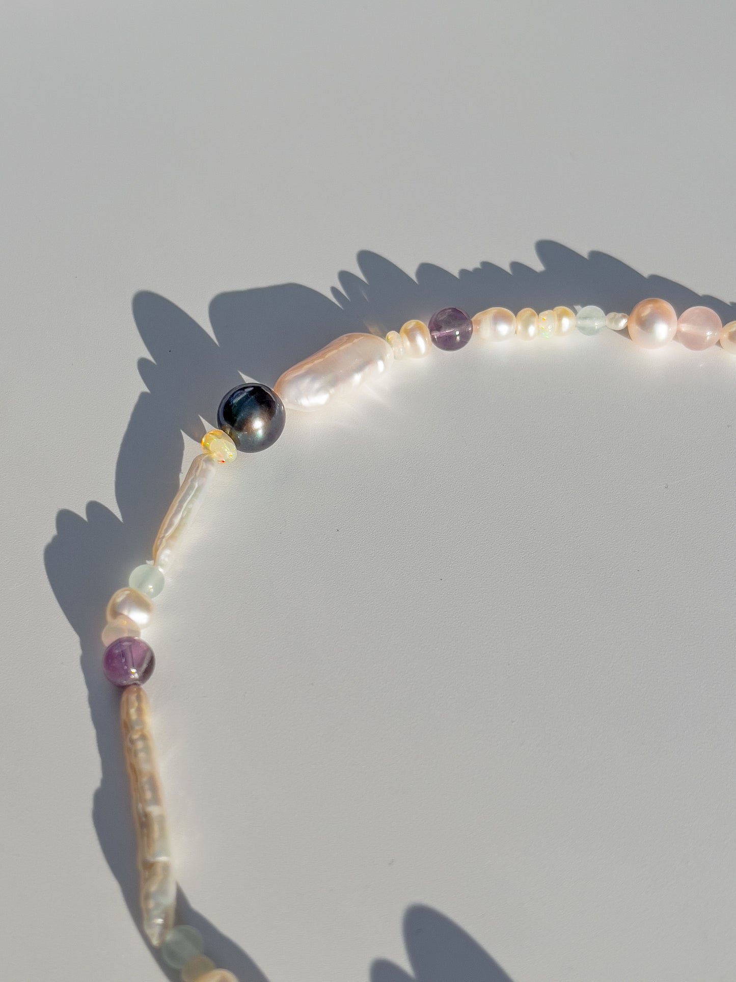 Tahitian Black Pearl & Opal Multi-Stone Choker Necklace - Glistening in candy colours, and finished with Sterling Silver hardware, this necklace is absolutely gorgeous. Hand crafted with a variety of Vibrant White Keshi Pearls, Estate re-purposed Tahitian Black Pearls, Biwa Pearls, Freshwater Pearls & Pink Freshwater Pearls. Combined with a glittery cluster of Australian Opals, Aquamarine, Blue Lace Agate, Jade, and the ultimate - The Super Seven Stone.  Designed and personally handcrafted by Nāmaka