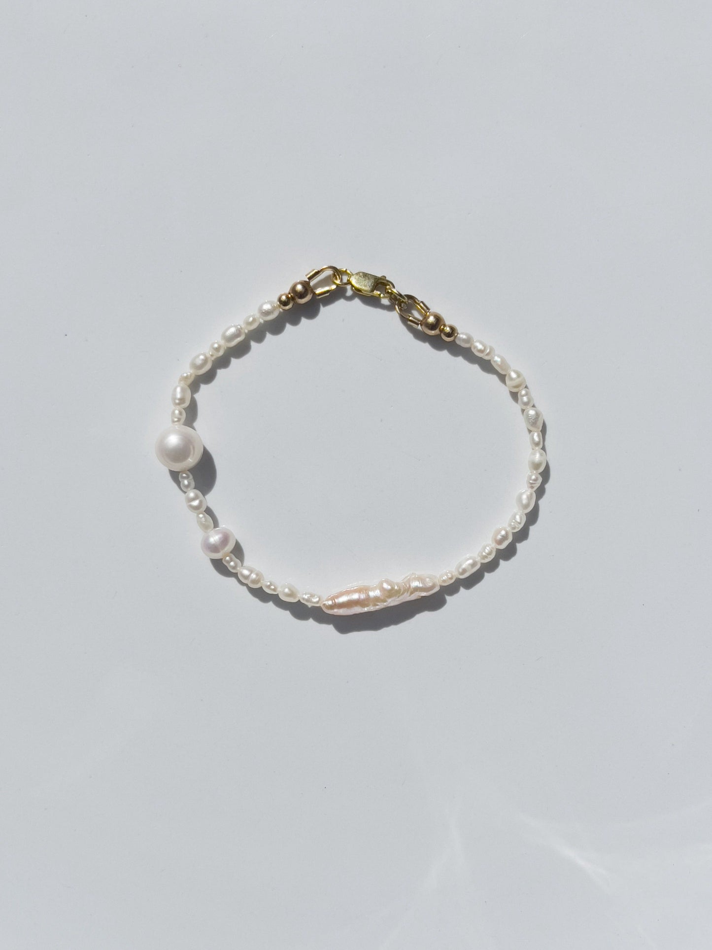 Biwa Pearl Bracelet. Natural elongated Biwa pearls placed off centre with a bold spherical Freshwater pearls. Using natural AAA quality freshwater pearls, in a minimal asymmetrical design. 14 Karat Gold filled Sterling Silver hardware finishes the piece. Designed and made by nāmaka