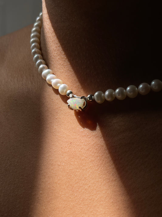 Pearl & Raw Opal Choker Necklace. Natural AA luxe pearls in a natural white are highlighted by the bright iridescent sparkle of Raw Australian Opal placed centrally on the clavicle, held in a sterling silver setting.  Personally and strung and knotted with 100% silk thread & handcrafted in Sterling Silver.   This necklace is a true statement piece.  Please note that this style is made to order, and due to the natural and raw elements, each piece is completely unique.