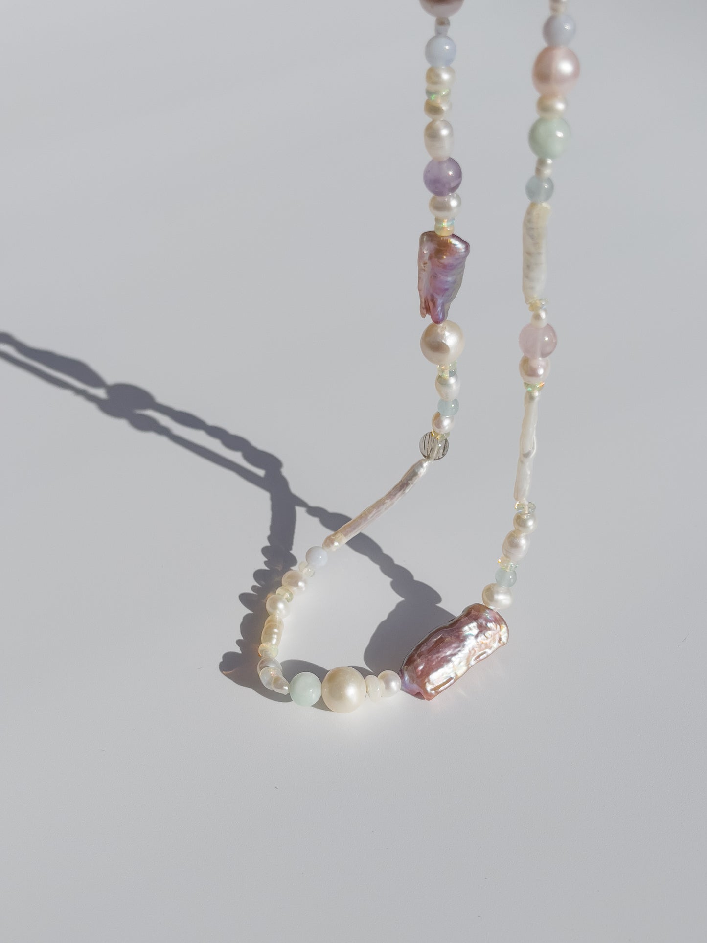 Candy Pearl & Multi-stone Necklace - Glistening in candy colours, and finished with 14 karat Gold hardware, this necklace is absolutely gorgeous. Hand crafted with a variety of Violet Keshi Pearls, South Sea Pearls, Biwa Pearls, Freshwater Pearls & Pink Freshwater Pearls. Combined with a glittery cluster of Australian Opals, Aquamarine, Blue Lace Agate, Jade, and the ultimate - The Super Seven Stone. Designed and made by nāmaka